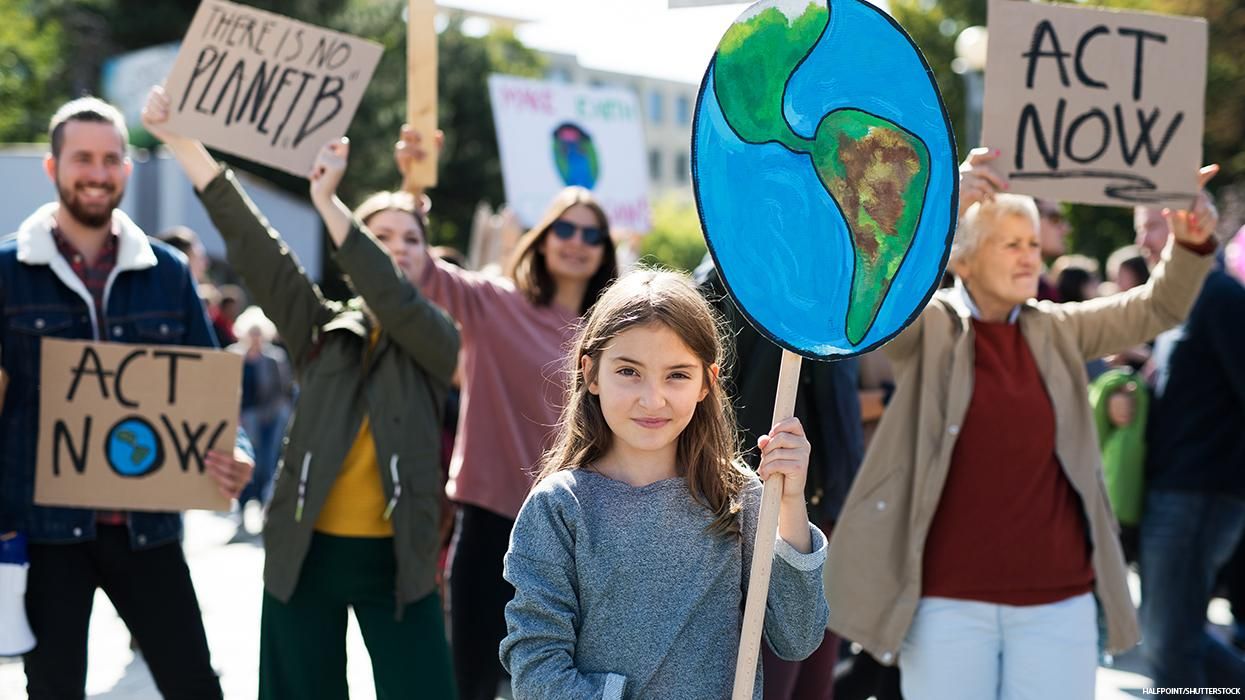 A young girl holds a sign at a climate change protest