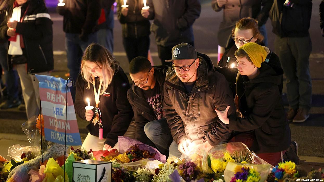 People kneel at a memorial for Club Q shooting victims