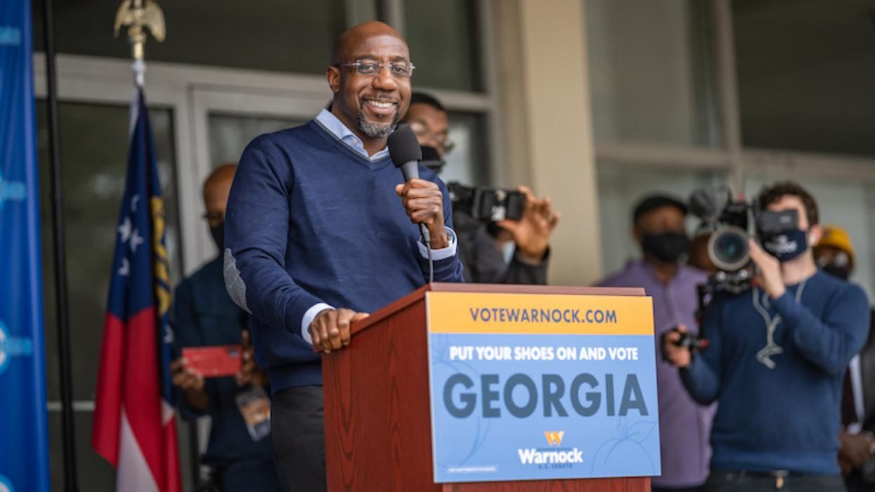 Raphael Warnock stands at a campaign podium
