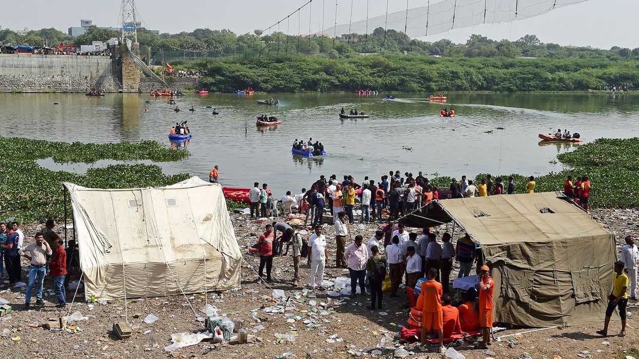 	Rescue workers conduct search operations after a bridge across the river Machchhu collapsed at Morbi in India's Gujarat state on October 31.