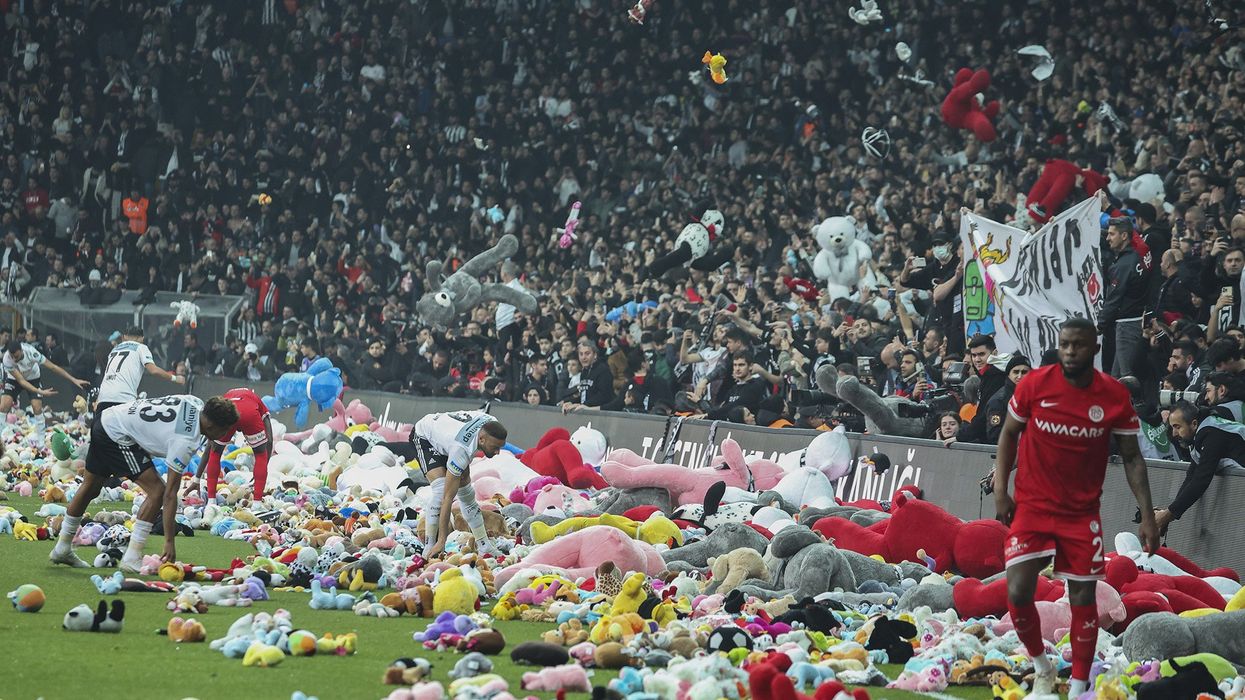 Soccer fans throwing stuffed animals onto the pitch